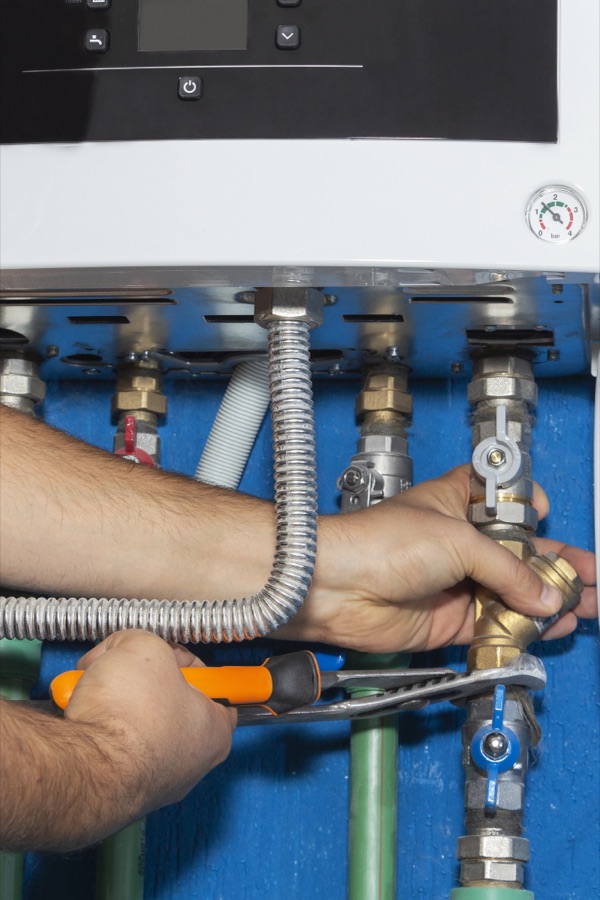 Plumber installing a boiler and pipework